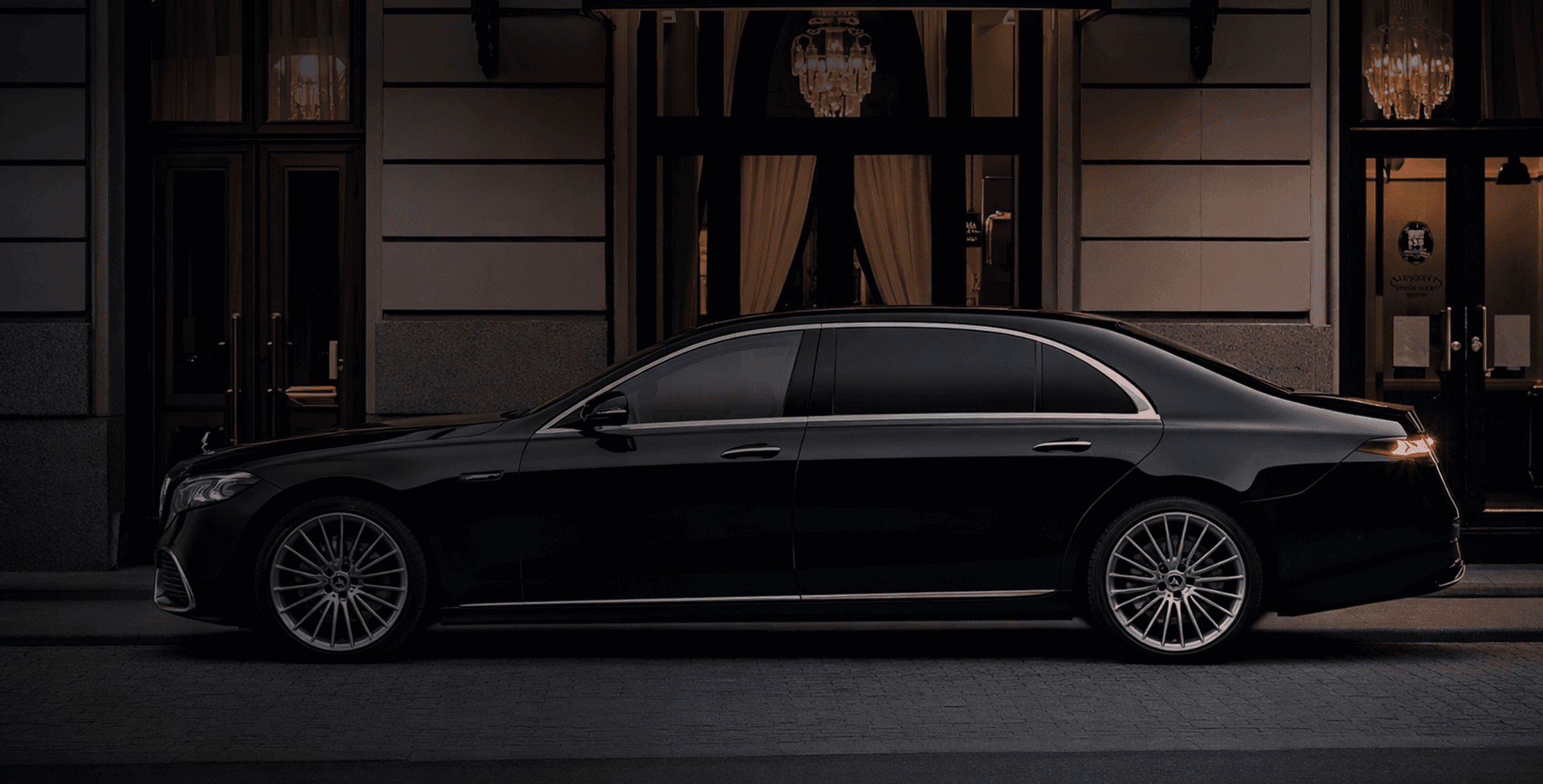 Luxury chauffeured sedan in front of an elegant building