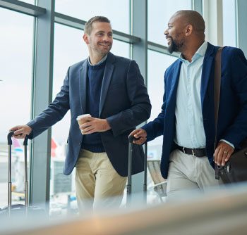 two business men arriving at airport feeling happy after their corporate transportation service with sunny limo